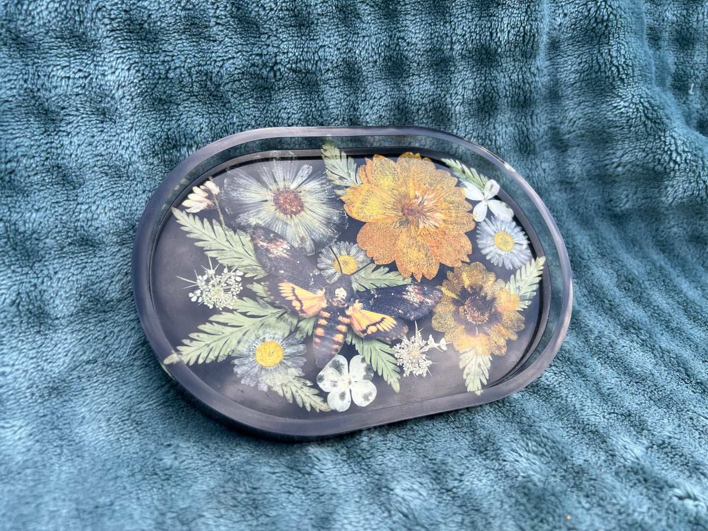Schale mit Blumen und falscher Totenkopfmotte