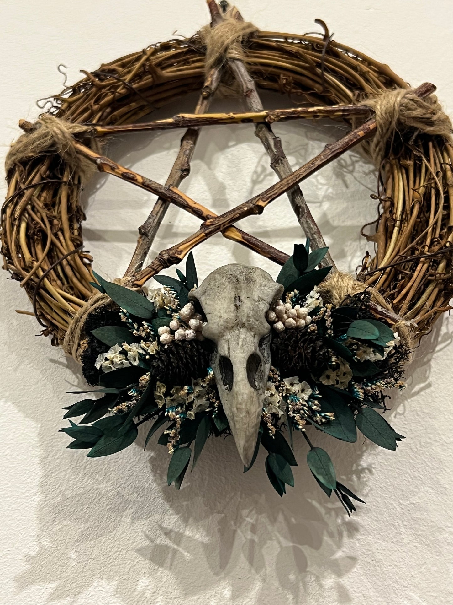 Kranz mit Vogelschädel und Blumen